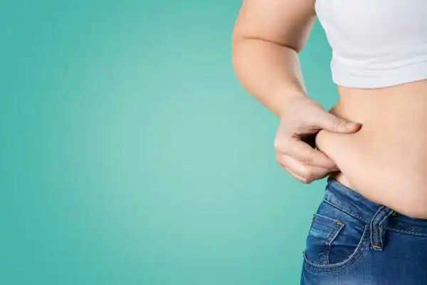 Image of woman pinching her love handles to show weight gain Peak Dale